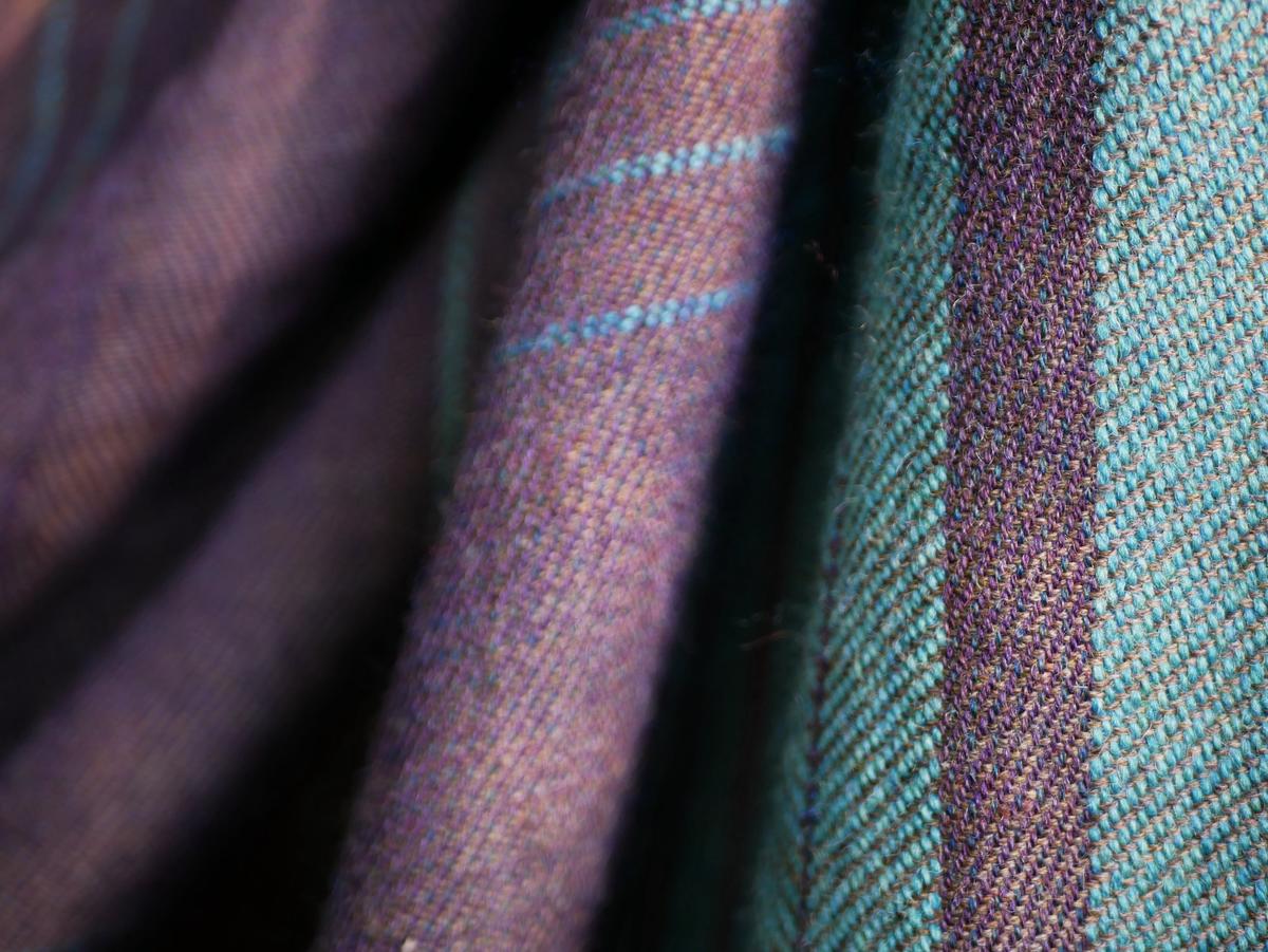 close up, the softly draping wool reveals it's a mixture of purple, blue, and brown