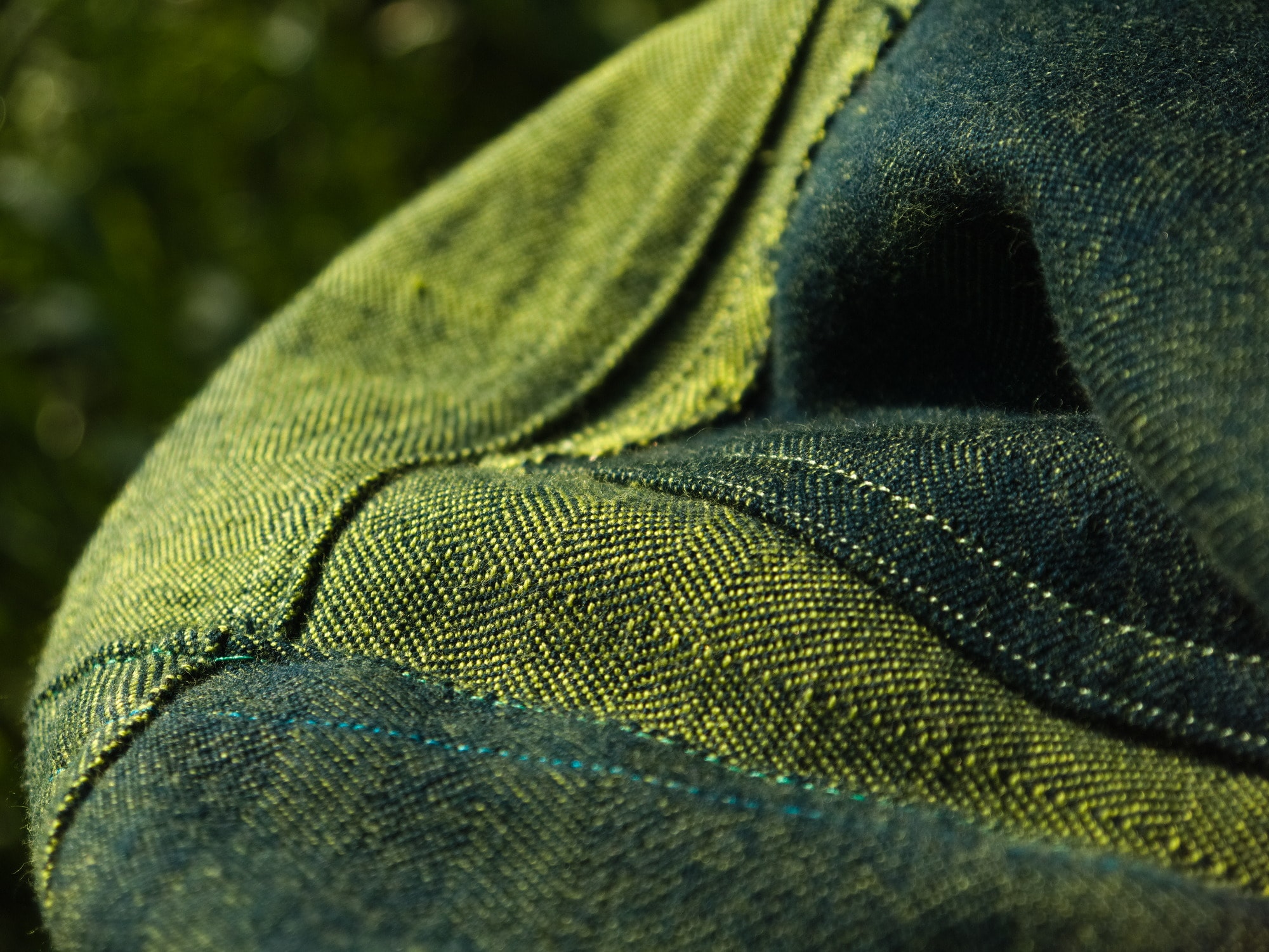 a blue pocket is folded over, showing the denim's green underside.
