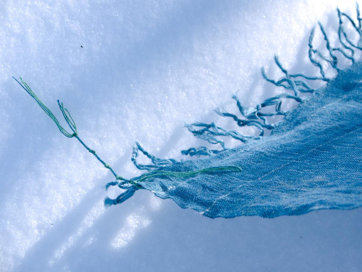 tzitzit lying on sparkling snow, raked by shallow sunlight
