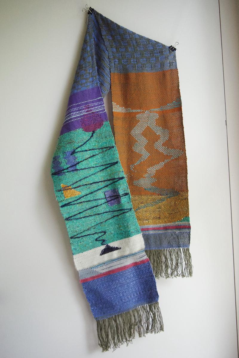 a  figurative scarf hanging in front of a white wall.
